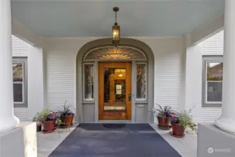 The large porch and arched doorway welcome you in.