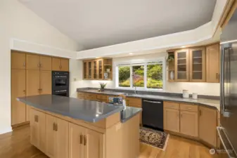 The open kitchen with its large center island and top-of-the-line appliances (Viking cooktop, double ovens, and dishwasher; Bosch refrigerator) will delight any chef