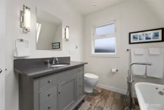 The upper level bathroom is bright and spacious and home to a stately, refinished clawfoot tub.