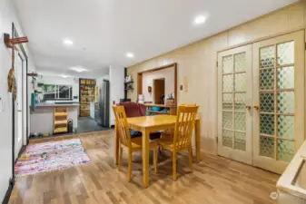 The dining room features hardwood floors and French doors to the front of the home, and French doors leading to the hallway and bedrooms features retro, tinted, bottle glass window panes.