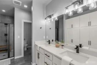 Primary ensuite features a double-sink vanity, walk-in shower, built-in cabinetry and a water closet.