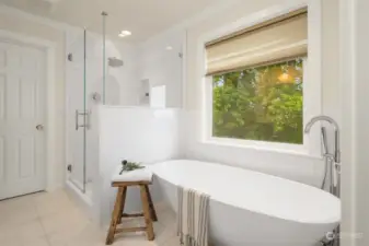 Free-standing tub with floor-mounted fixtures and beautifully tiled shower