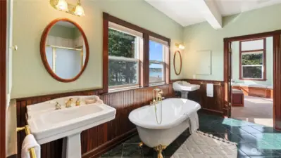 Double pedestal sinks and wood bead board trim detailing bring in the traditional Victorian charm.