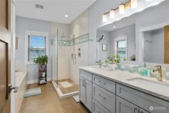 In the primary bathroom, you'll find a double sink vanity, a walk-in tile shower with dual shower heads, a separate toilet room, and a luxurious soaking tub.