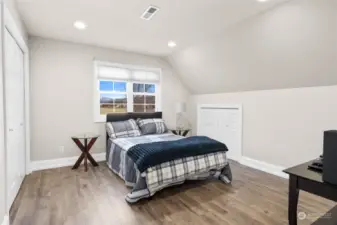 Third of three bedrooms on upper level, also with newly installed luxury plank vinyl flooring. Additional storage closets to the right of the bed.