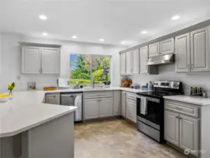 The kitchen was recently remodeled with designer colored cabinets, quartz counter tops, and an L shaped island with space for 3 barstools.