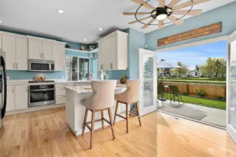 The casual eating space with the unique and fun ceiling fan, has French doors that open to that fabulous water view of 2 lakes with the center walking bridge.
