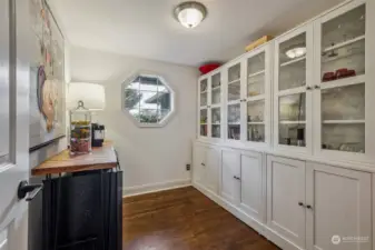 Off of the main entry you'll find the office/den. Again, reimagined and repurposed here with built-in white cabinetry and used as a butler panty/bar room. Or, convert back if preferred.