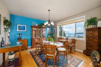 The formal dining room with its rich hardwood floor and spectacular views of Puget Sound, downtown Seattle, the Space Needle, the Cruise Ship Docks and Blake Island.