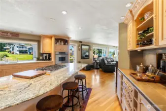Spacious kitchen open to great room featuring granite island, wine bar and door to the outdoor paradise
