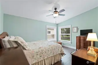 Primary suite with ceiling fan looks out to back yard.
