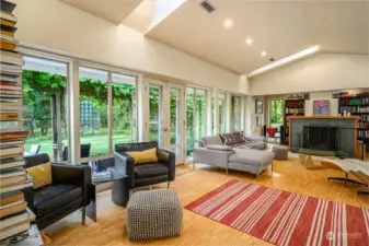 Large inviting living room has wood-burning fireplace, a cozy library space and opens out to the patio and yard
