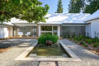 A private courtyard graces the entrance w/ reflection pond