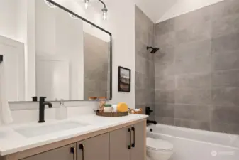 The upper full bathroom on the 2nd floor with a deep soaking tub and tiled floor and shower surround.
