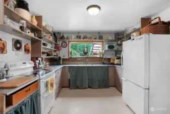Kitchen with eating area and lots of shelving. 2 pantries as well.