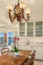 Dining room has a Butler's pantry with sink and marble countertops, cabinets for storing china and custom chandelier.