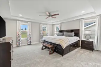 Primary bedroom, graced with a tray ceiling and an overhead fan, is a true retreat.