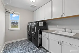 Convenient upper level laundry room with an abundance of storage and a laundry sink.