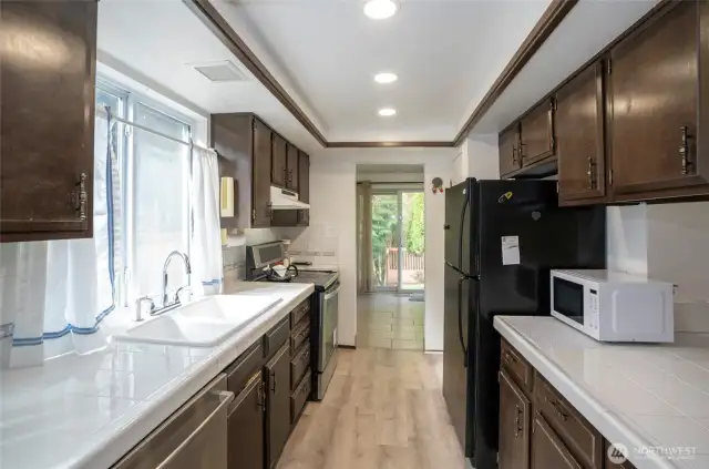 Enjoy the kitchen’s oversized windows above the sink, perfectly framing the peaceful backyard view.