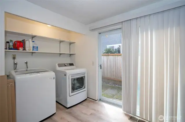 Utility area located off the kitchen, featuring additional shelving for easy organization.