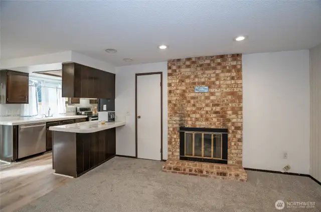 The family room features a warm and inviting gas fireplace, perfect for cozy gatherings, with a neatly tucked utility closet to the left for added convenience and functionality.