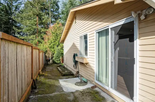 Convenient second sliding door off the kitchen opens to the walkway on the side of the home.