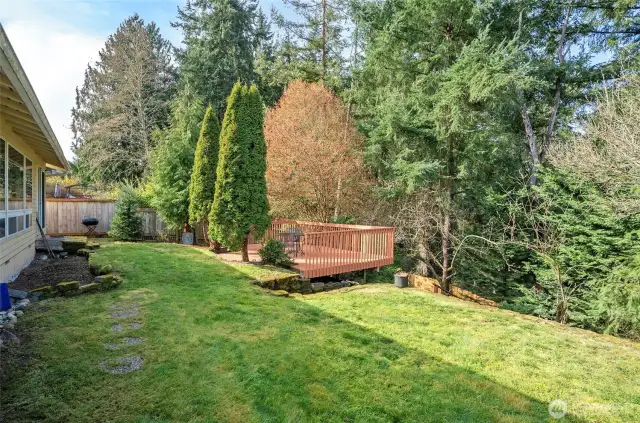 Another angle of the private backyard featuring the large deck, ideal for gatherings.