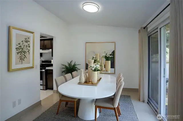 The light-filled dining area offers tile flooring and a sliding door that opens to a fenced backyard and deck, creating a perfect space for indoor-outdoor enjoyment - virtually staged for inspiration.