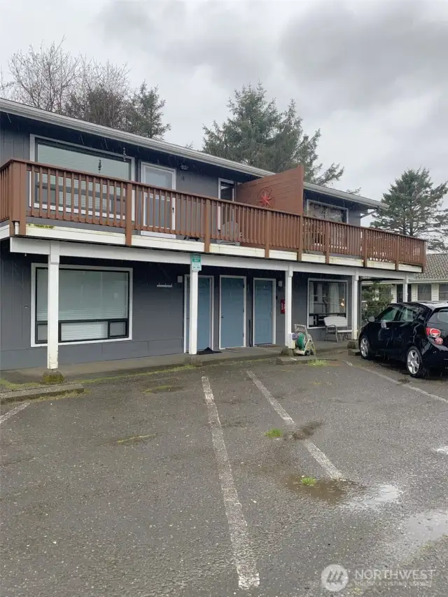 The middle door leads to the unit.  The parking spot is the empty one to the right in this photo.  It's marked '20', but it's hard to read.