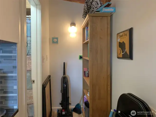 Between the kitchen and the fridge is a hallway that leads to the 3/4 bathroom.
