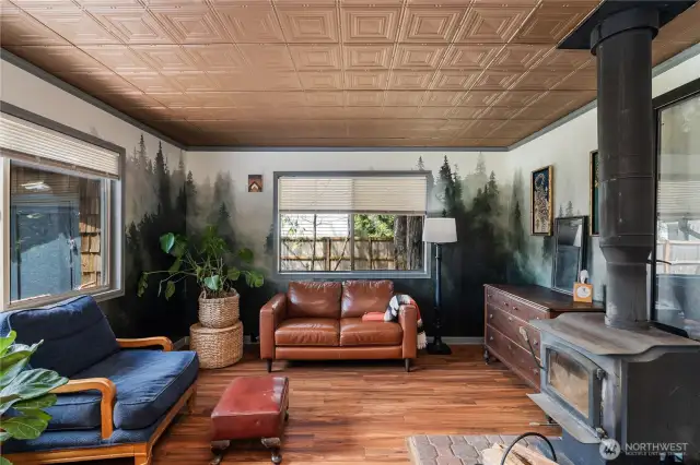 Living area with wood burning fireplace & unique wallpaper & ceiling design
