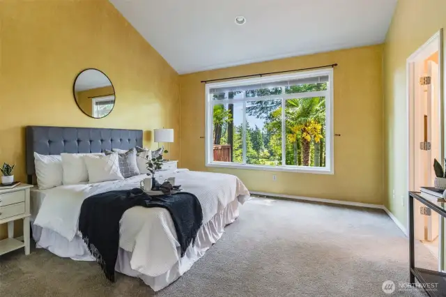 Main level primary suite with vaulted ceilings, beautiful picture window to greenbelt. French doors with interior transom window. Next to laundry room!