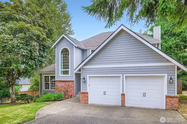 Inviting front elevation with clean lines, manicured lawn, and vibrant front door. Spacious driveway provides ample off-street parking.