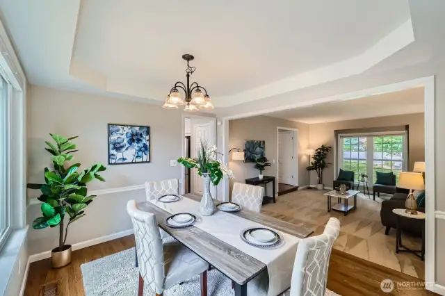 Open sight lines between dining and living areas. Elevated ceiling details and abundant natural light enhance the flow.