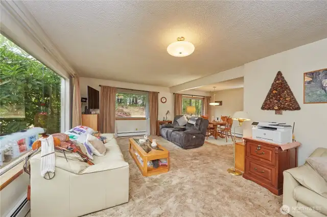 Living room/dining area features large windows that fill the space with natural light.