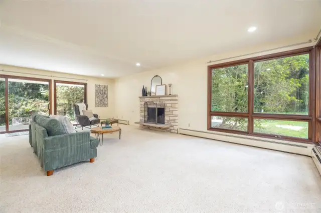 To the right of the front door is a large bright living room with windows on 3 sides looking out to the tranquil property.