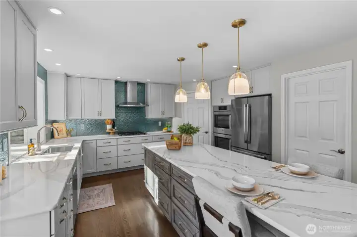 This kitchen is the chef's kiss!  Gas range, quartz counters, huge island, and more