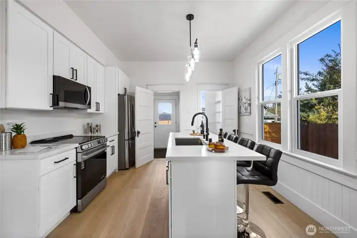 The gorgeous kitchen features all new soft-close cabinets, quartz counters, stainless appliances, and island seating.  All new fixtures and finishes!