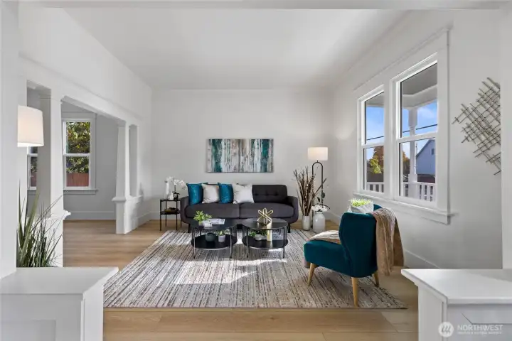 The formal living room boasts a ton of space with excellent natural light. Don't miss the vintage columns, the crown molding, the tall base over the all new flooring, and the fully wrapped and trimmed new windows.