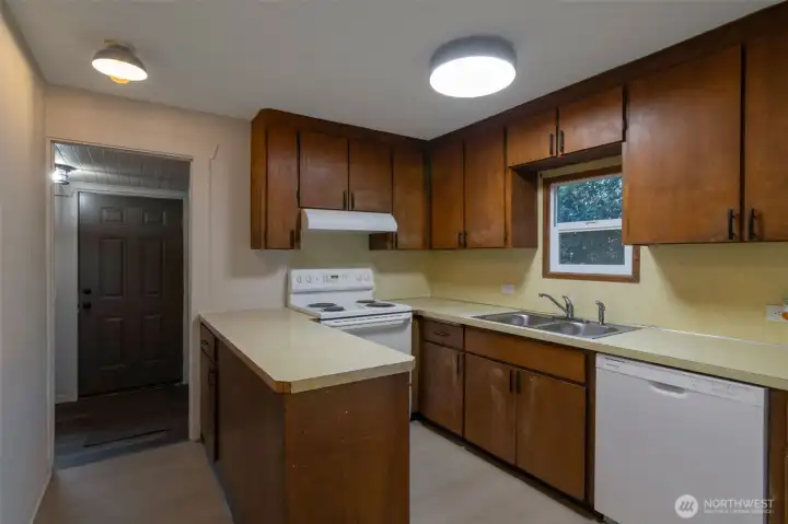 Kitchen with new appliances leads to rear mud room