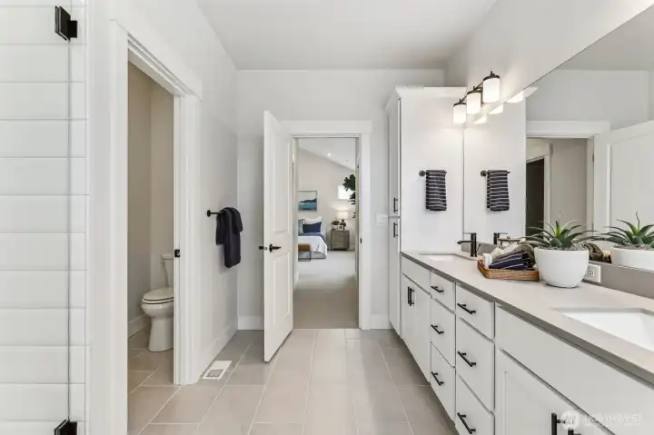 Pic is of model- Primary bath with frameless shower w/extensive tile floor, walls and blk plumbing fixtures and knobs.  Separate-private water closet.