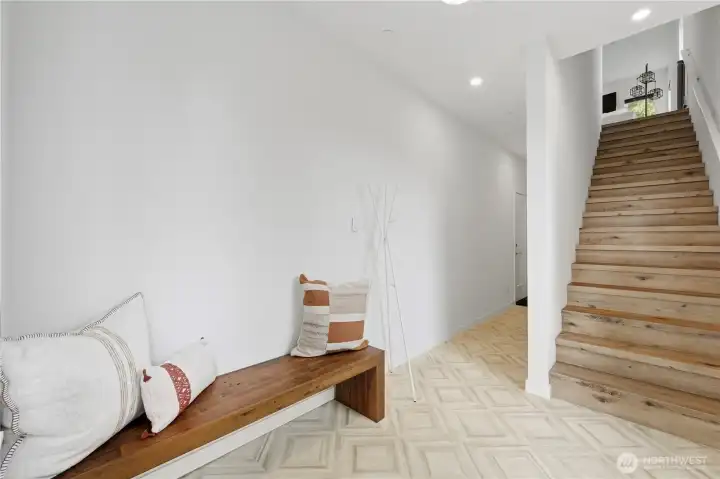 Hallway leads to den/office, garage and entry closet/storage under stairs. Hallway leads to den/office, garage and entry closet/storage under stairs.