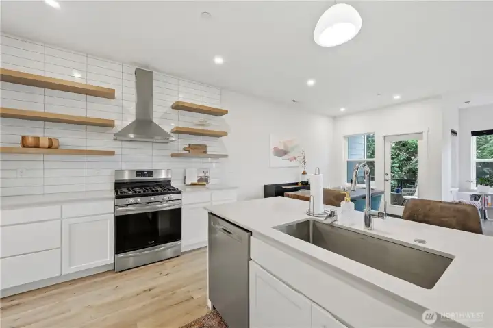 Delightful kitchen with floating shelf accents and quarts counters Delightful kitchen with floating shelf accents and quarts counters