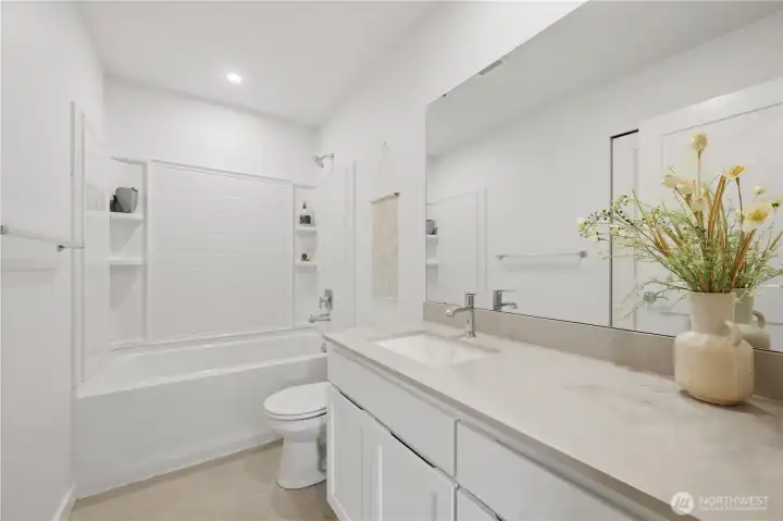 Main full bath adjacent to bedrooms 2 & 3 with quartz counters