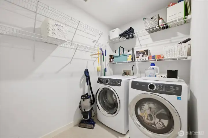 Laundry room with added storage shelves next to full bath