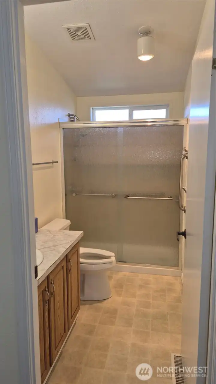 Tiled main bath with tiled walk-in shower.