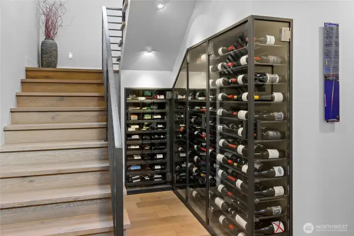 Also in the vaulted foyer,  Coates Design embellishments of a custom-built glassed-in temperature-controlled wine storage for 309 bottles.