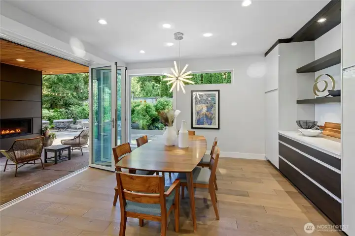 Nano system patio doors seamlessly open up the dining and living areas to covered patio seating with a fireplace and an outdoor bbq kitchen.