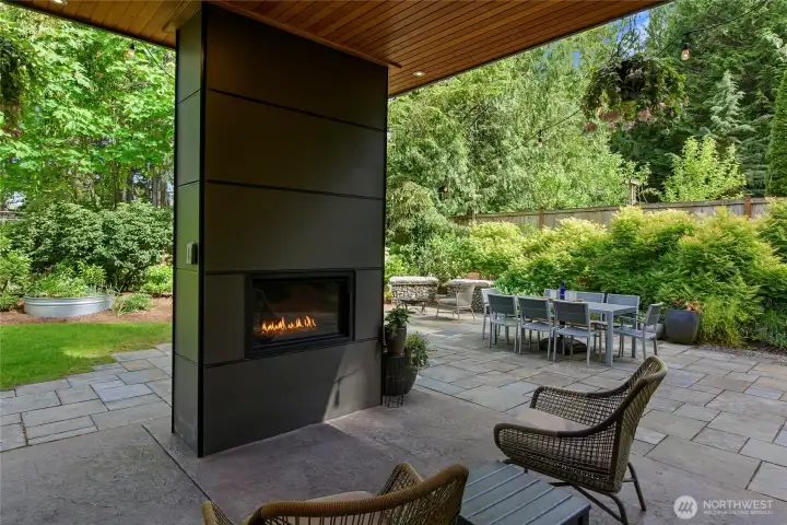 Covered patio seating with a fireplace.