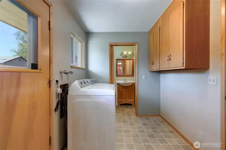 Large laundry room with back door to the left of photo and half bath straight ahead.  The half bath backs up to the expansive "costco room" in the garage so owners say bath room has the possibility of being extended into a 3/4 bath. Buyers to verify.